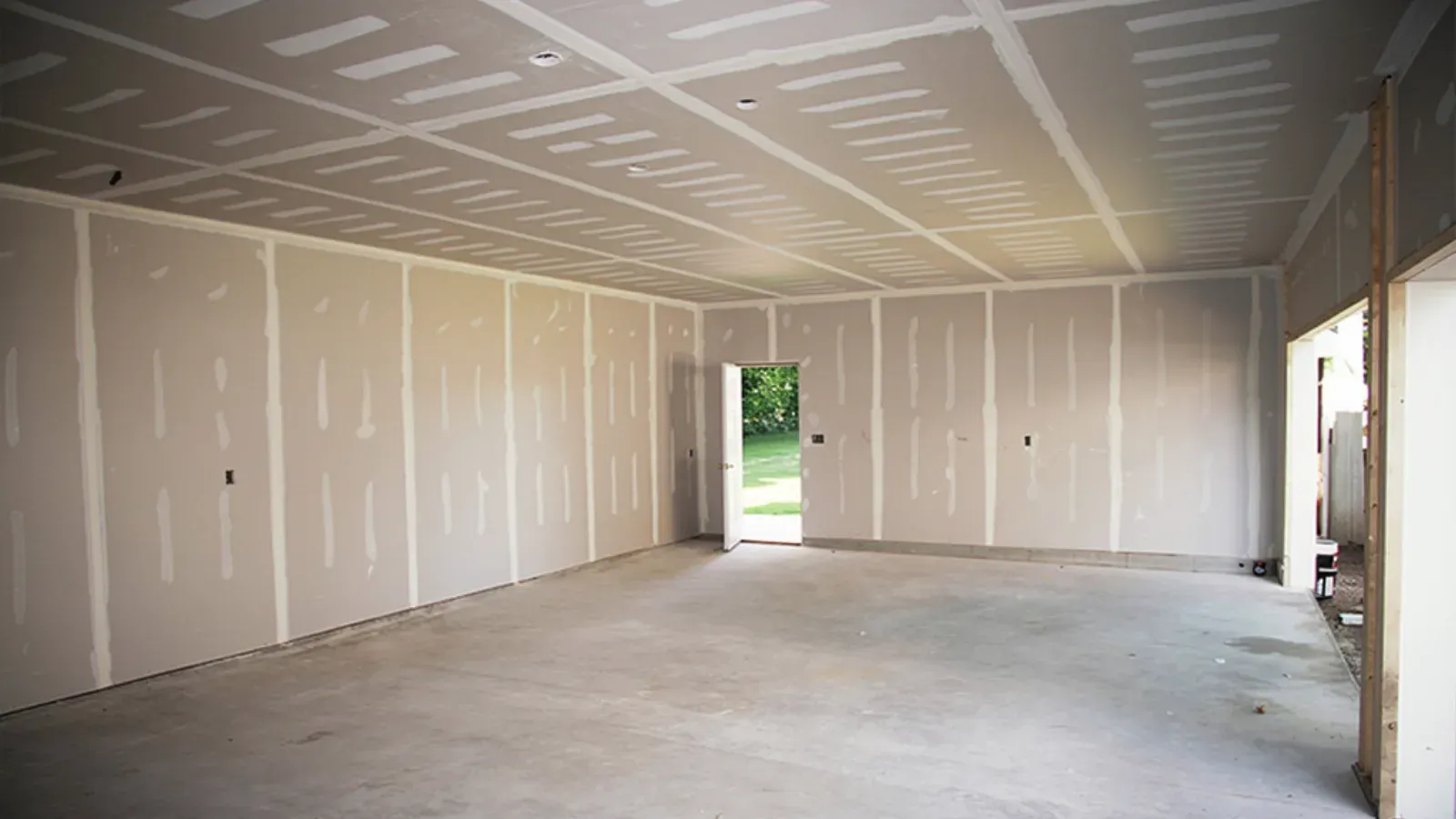 Fire-rated drywall assembly taped across a garage ceiling and side walls